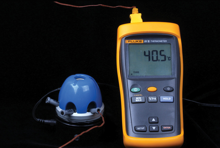 Thermocouple probe placed inside a compule of resin composite in a composite warmer.