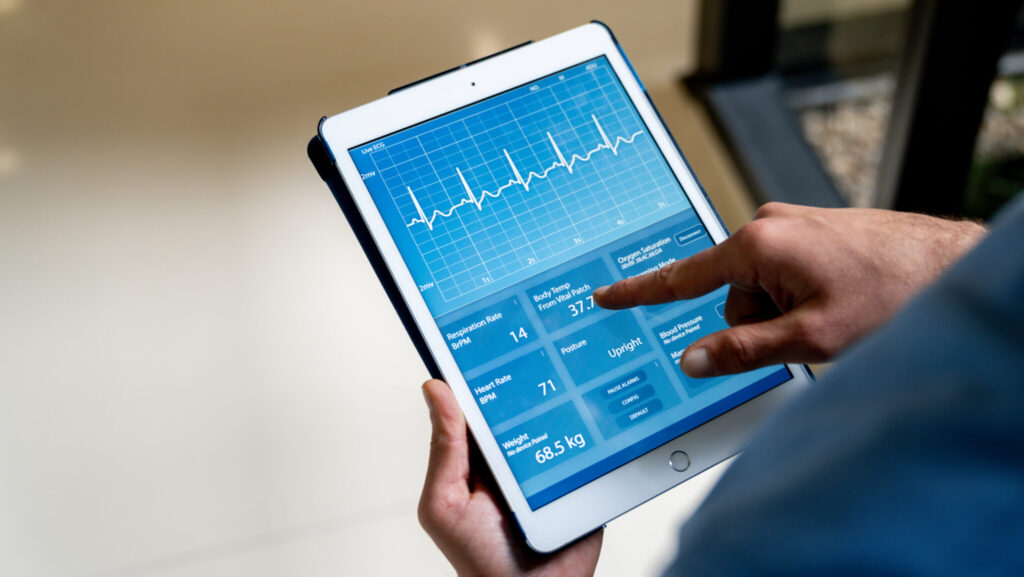 Close-up on a doctor monitoring the vital signs of a patient at the hospital using a digital tablet
