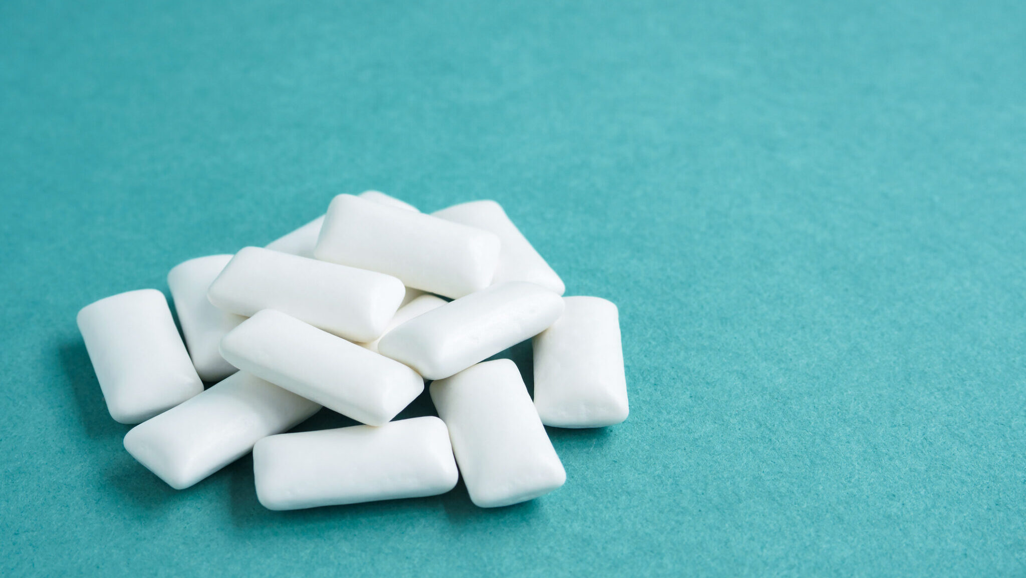 heap of chewing gums on blue background, copy space.