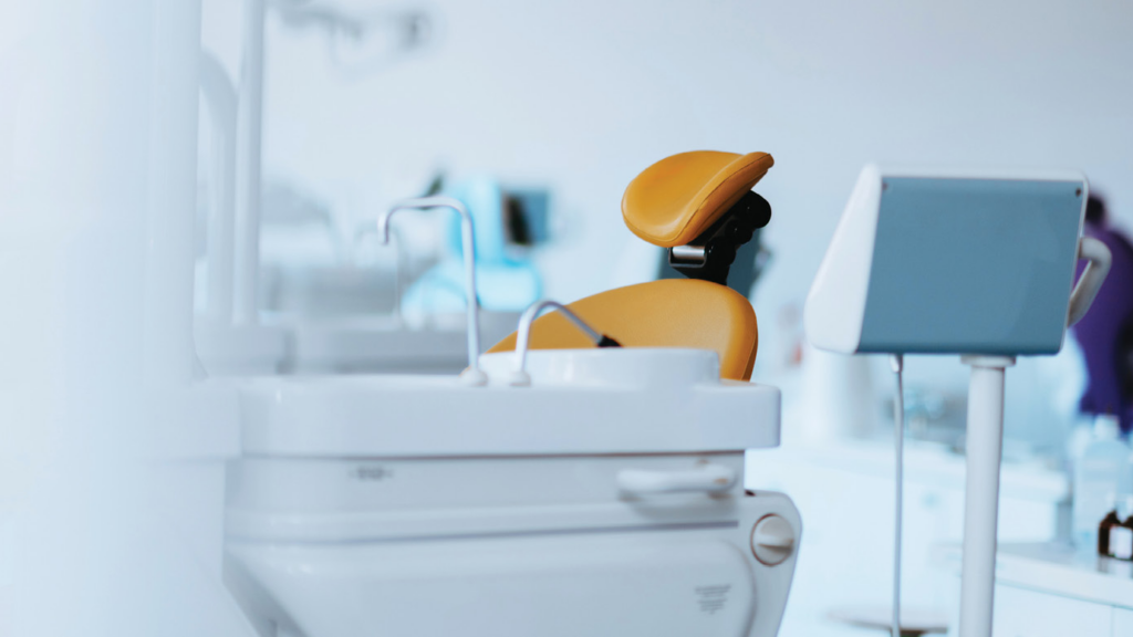 A bright and minimalist dental clinic with a sterile and sophisticated design. The well-lit, organized environment ensures a welcoming and professional atmosphere for patients, emphasizing hygiene and advanced dental care.